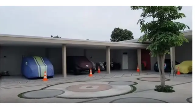 Luasnya garasi rumah Bu Dendy, terdapat deretan mobil dan motor.