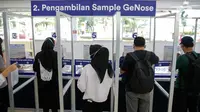 Calon penumpang kereta api mengambil kantong untuk melakukan tes deteksi COVID-19 dengan GeNose C19 di Stasiun Gambir, Jakarta, Rabu (24/3/2021). PT KAI (Persero) menaikkan tarif pemeriksaan tes GeNose C19 dari Rp20 ribu menjadi Rp30 ribu mulai 20 Maret 2021. (Liputan6.com/Faizal Fanani)