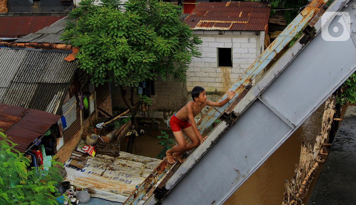 Seorang anak menaiki jembatan sebelum melakukan aksi lompat di Jembatan Ciliwung Kalibata, Jakarta, Selasa (25/2/2020). Beberapa anak nekat bermain air dengan lompat dari atas jembatan Ciliwung Kalibata, Jakarta, Selasa (25/2/2020). (merdeka.com/magang/Muhammad Fayyadh)