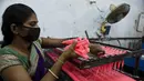 Seorang pekerja membuat lilin jelang Festival Cahaya Diwali di sebuah pabrik pinggiran Ahmedabad, India, 4 November 2020. (SAM PANTHAKY/AFP)