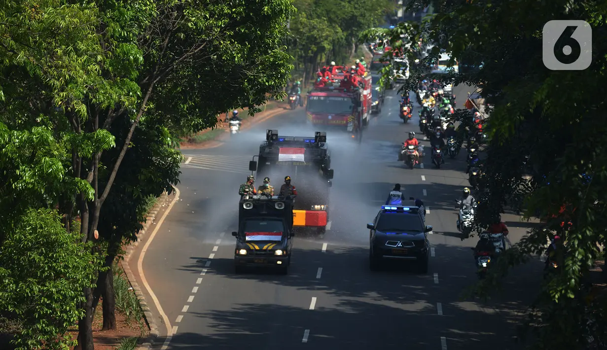 Petugas gabungan melakukan penyemprotan cairan disinfektan di sepanjang jalan raya di wilayah Jakarta Timur, Selasa (25/8/2020). Penyemprotan ini di bagi dua jalur utara dan Selatan. (merdeka.com/Imam Buhori)