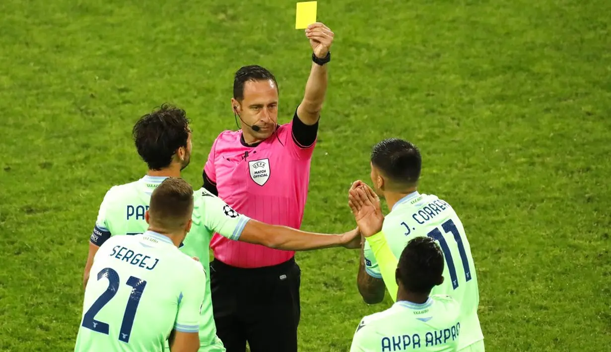 Wasit Artur Dias memberi kartu kuning kepada pemain Lazio Jean-Daniel Akpa Akpro (kedua kanan) saat menghadapi Zenit St. Petersburg pada pertandingan Grup F Liga Champions di Stadion Saint Petersburg, Rusia, Rabu (4/11/2020). Pertandingan berakhir dengan skor 1-1. (AP Photo/Mike Kireev)