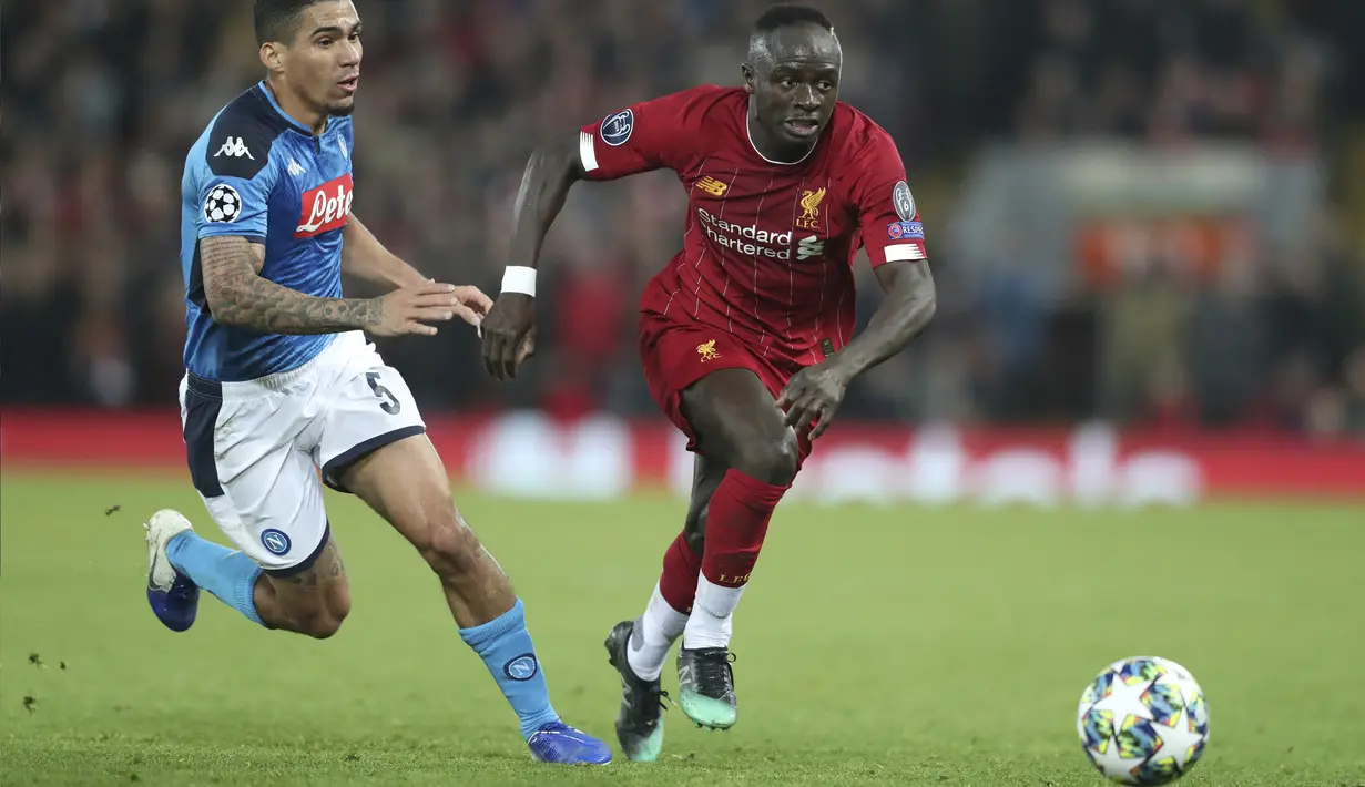 Penyerang Liverpool, Sadio Mane (kanan) menggiring bola dari kejaran gelandang Napoli, Allan pada pertandingan Grup E Liga Champions di stadion Anfield, Inggris (27/11/2019). Liverpool bermain imbang 1-1 atas Napoli. (AP Photo/Jon Super)