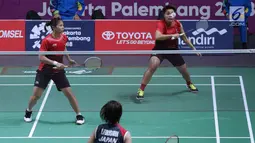 Ganda putri Indonesia, Greysia Polii/Apriyani Rahayu mengembalikan kok ke arah pemain Jepang, Yuki Fukushima/Sayaka Hirota pada semifinal Bulutangkis Beregu Putri Asian Games 2018 di Jakarta, Selasa (21/8). (Liputan6.com/Helmi Fithriansyah)