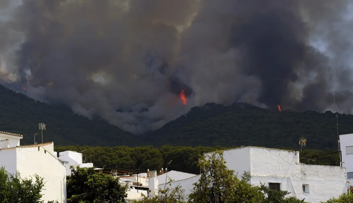 <p>Kebakaran meluas di dekat daerah perumahan di Alhaurin de la Torre, Malaga, Spanyol, Sabtu (16/7/2022). Gelombang panas yang melanda Spanyol memicu api menyebar lebih cepat dan menghambat upaya pengendalian kebakaran. (AP Photo/Gregorio Marrero)</p>