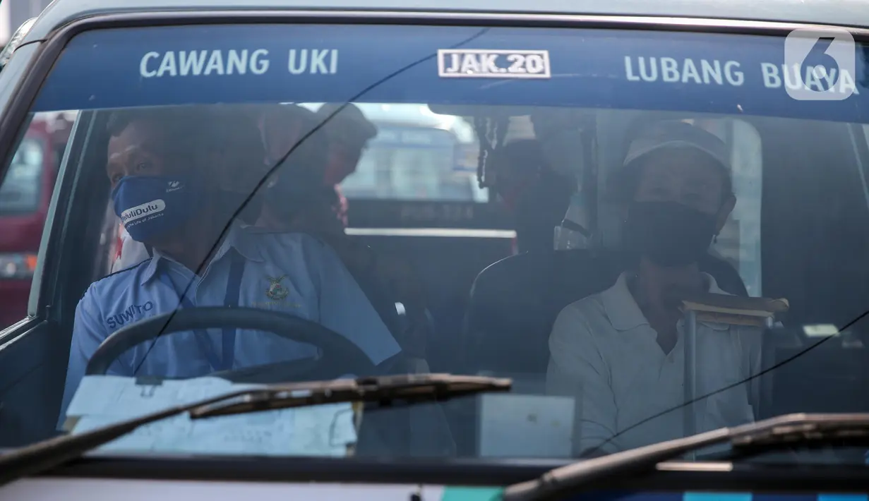 Sopir angkutan umum Jak Lingko mengenakan masker dan sarung tangan di kawasan Cawang, Jakarta, Senin (6/7/2020). Pada perpanjangan masa PSBB transisi, angkutan umum sudah mulai beroperasi kembali dengan menerapkan protokol Kesehatan Covid-19. (Liputan6.com/Faizal Fanani)