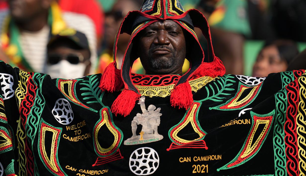Seorang Suporter Kamerun menari sebelum dimulainya pertandingan sepak bola grup A Piala Afrika 2021 antara Kamerun melawan Burkina Faso di stadion Olembe di Yaounde, Minggu, (9/1/2022). Piala Afrika 2021 seharusnya digelar Januari 2021 tapi kemudian diundur karena pandemi. (AP Photo/Themba Hadebe)