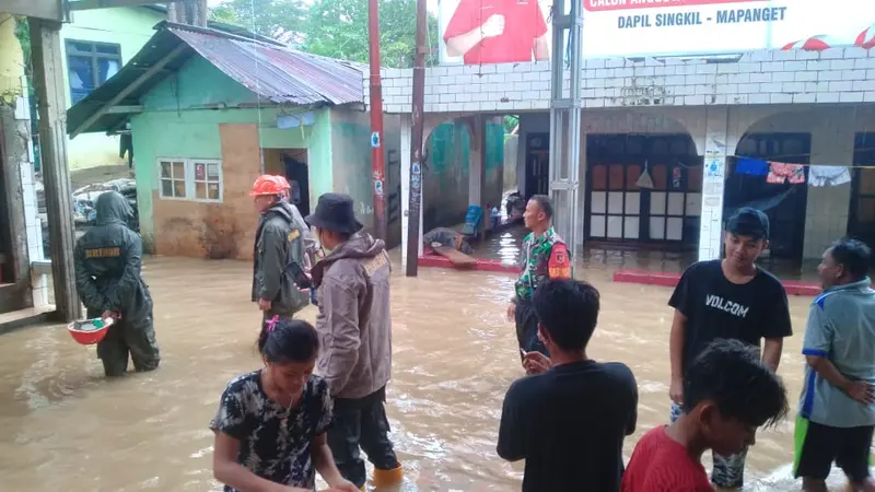Babinsa Ternate Tanjung, Kodim 1309/Manado Sertu Sutimin bersama instansi terkait melakukan evakuasi warga yang terjebak banjir di Ternate Tanjung, Kecamatan Singkil, Kota Manado, Sulut, Minggu (21/1/2024).