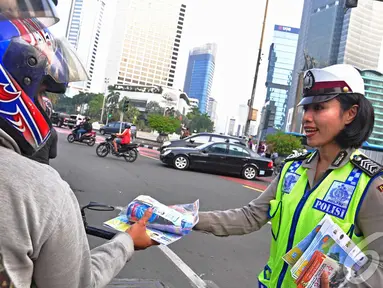 Petugas Kepolisian Direktorat Lalu Lintas Polda Metro Jaya bagikan peta mudik gratis, Jakarta, Jumat (18/07/2014)(Liputan6.com/Faizal Fanani)
