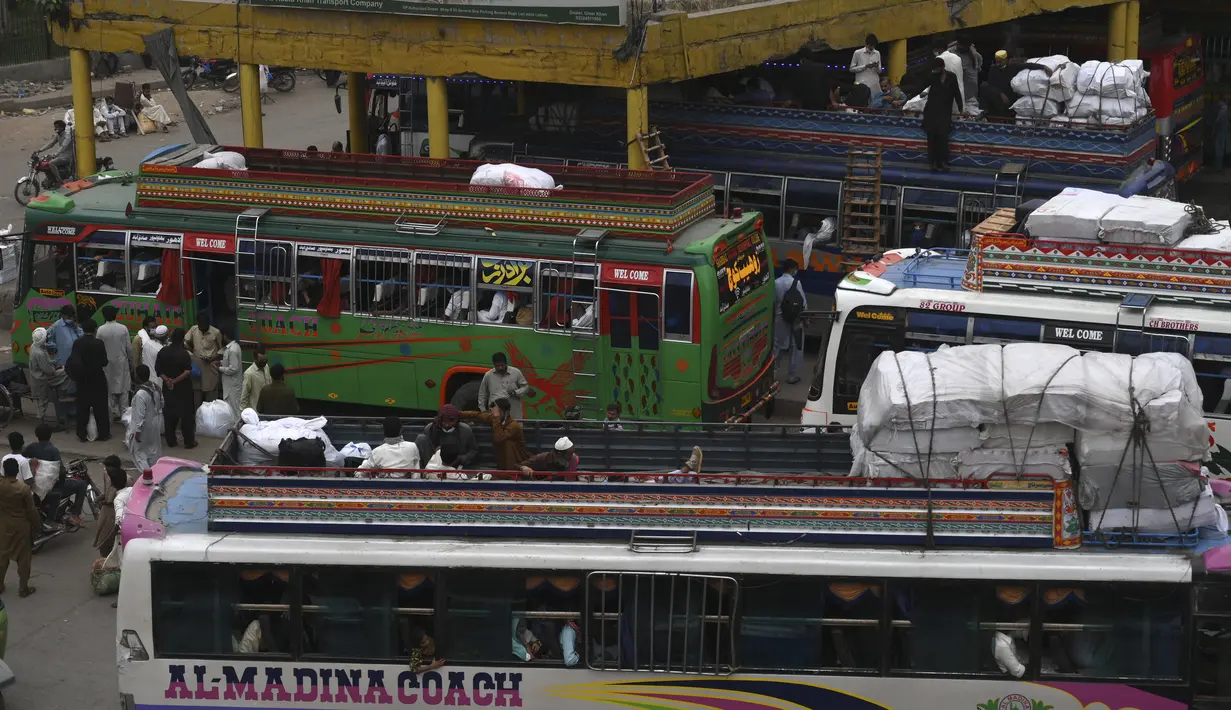 Warga menaiki bus saat mereka melakukan perjalanan ke kampung halaman mereka menjelang perayaan Idul Fitri di Lahore (7/5/2021). Lebaran Idul Fitri jatuh pada 13 Mei 2021. (AFP Photo/Arif Ali)