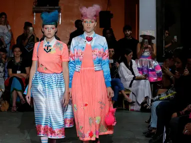 Dua model memperagakan busana Spring/Summer 2017 karya desainer asal India, Manish Arora selama Paris Fashion Week di Paris, Prancis (29/9). Model tersebut tampil dengan gaya rambut yang unik. (REUTERS/Gonzalo Fuentes)