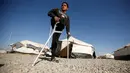 Jasim Abudllah saat berada di sekitar kamp pengungsian Debaga, Erbil, Irak (24/11). Bocah berumur 13 tahun tersebut, terpaksa harus kehilangan kaki kanannya akibat terkena serangan udara di Baiji. (Reuters/Mohammed Salem)