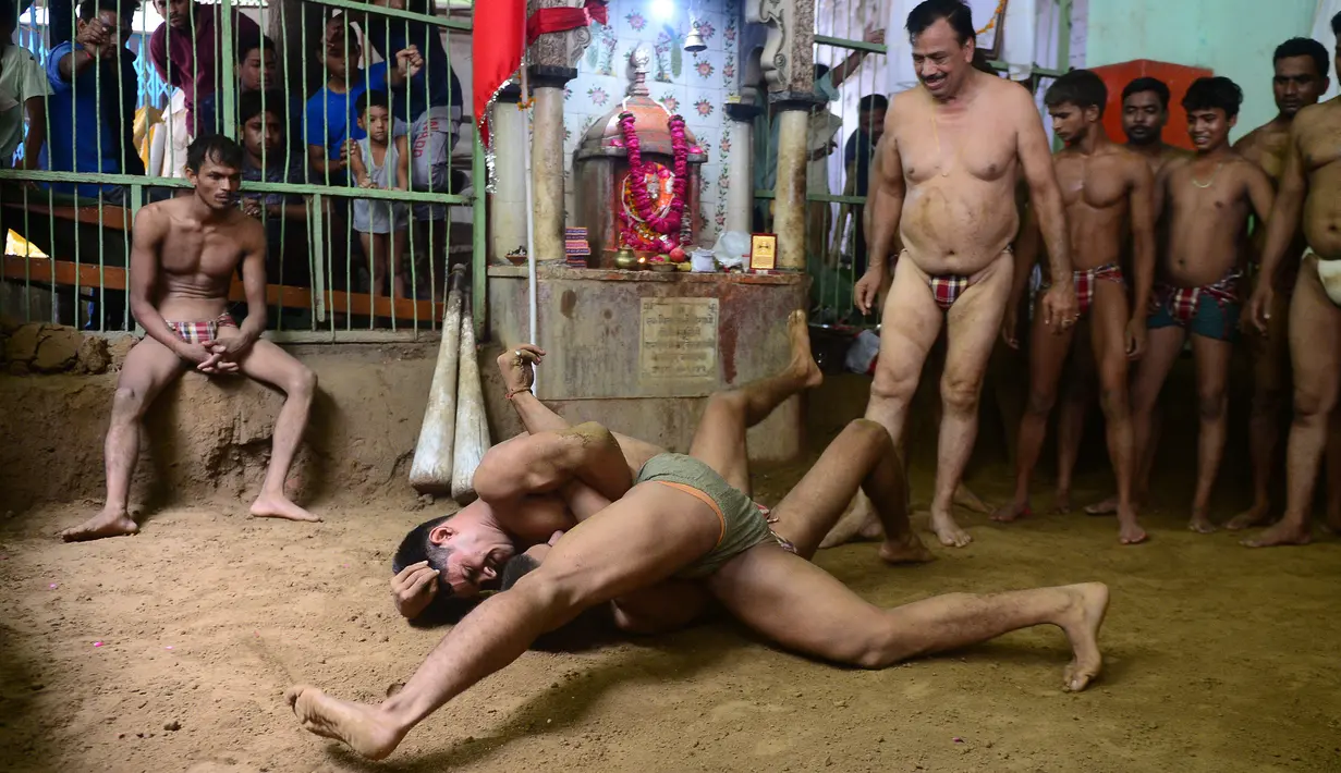 Pegulat India bertarung dalam gulat tradisional di klub gulat Loknath Vyayamsala untuk menandai festival Nag Panchami, di Allahabad (15/8). Di beberapa kota utara Festival Hindu Nag Panchami mengadakan gulat tradisional. (AFP Photo/Sanjay Kanojia)
