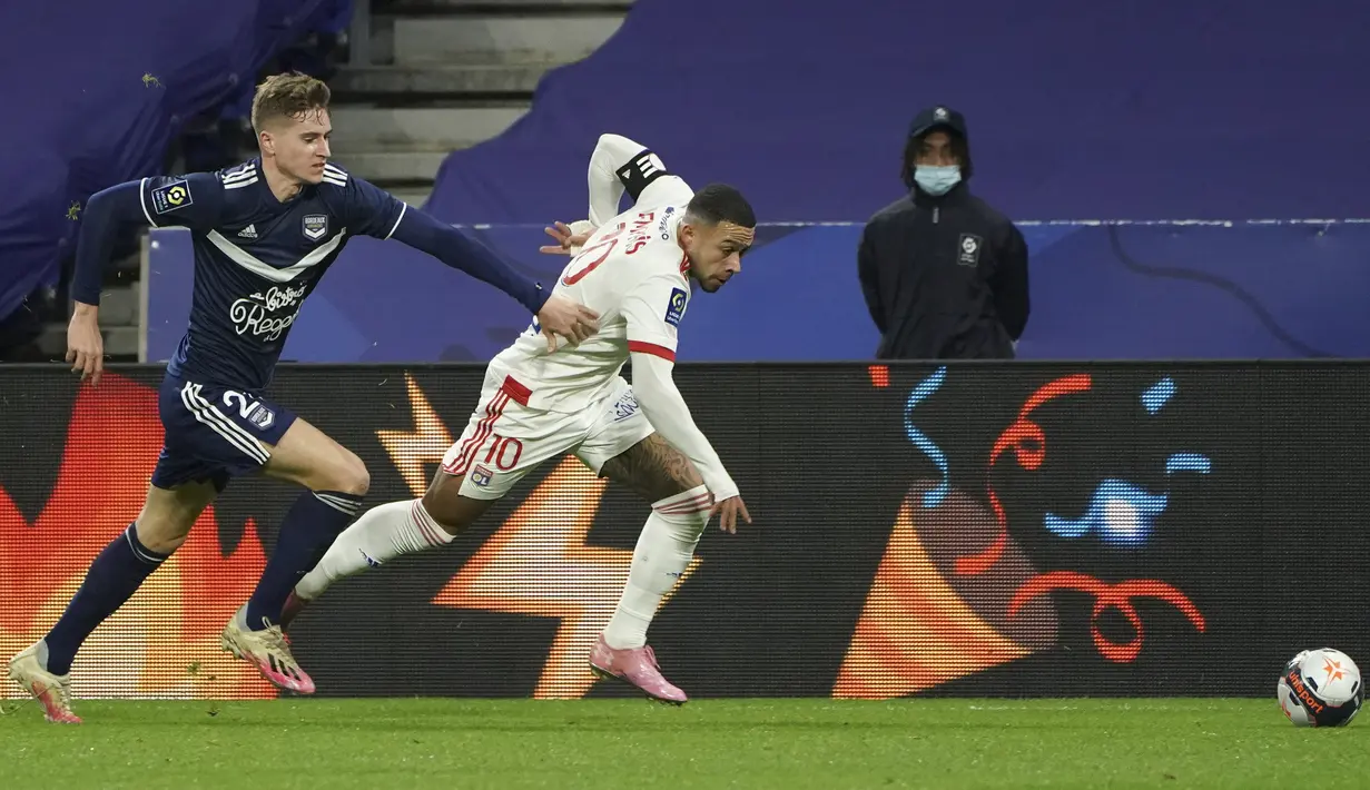 Striker Lyon, Memphis Depay (kanan) dan gelandang Bordeaux, Toma Basic berlari memburu bola dalam laga lanjutan Liga Prancis 2020/21 pekan ke-22 di Groupama Stadium, Jumat (29/1/2021). Lyon menang 2-1 atas Bordeaux. (AP/Laurent Cipriani)