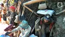 Mereka bekerja merangkak tertatih-tatih menyeret badannya sejauh puluhan meter dalam lubang sempit, kemudian membawa material tanah, batu dengan karung menyeretnya ke luar lubang. (merdeka.com/Arie Basuki)