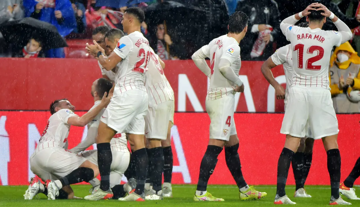 Para pemain Sevilla merayakan gol ke gawang Barcelona yang dicetak Papu Gomez pada laga Liga Spanyol 2021/2022 di Ramon Sanchez Pizjuan Stadium, Sevilla (21/12/2021). Dari total 197 laga di semua ajang, Barcelona tercatat kalah sebanyak 45 kali dari Sevilla dan menang dalam 113 laga. (AFP/Jose Jordan)