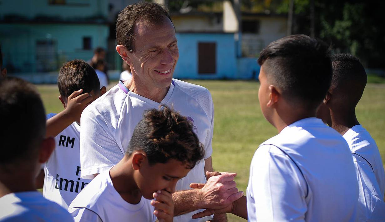 Emilio Butragueno menyalami anak-anak dari Real Madrid Foundation usai memberikan pelatihan sepak bola. (AFP/Yamil Lage)