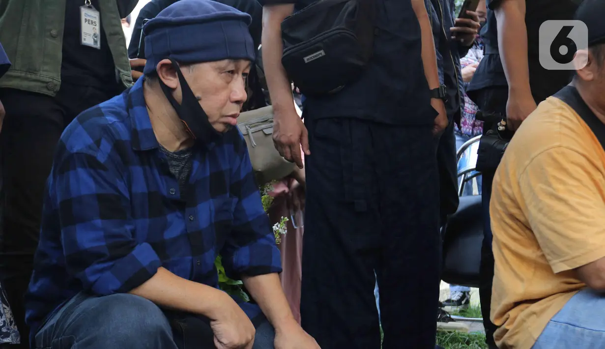 Pelawak Rudi Sepit saat mengahadiri pemakaman Rini S Bon Bon di TPU Kawi Kawi, Johar Baru, Jakarta, Senin (11/7/2022). Pelawak Rini S Bon Bon  meninggal dunia pada hari Minggu sore (10/7/2022), sebelum berpulang rini sempat mengidap  sakit diabetes. (Liputan6.com/Herman Zakharia)
