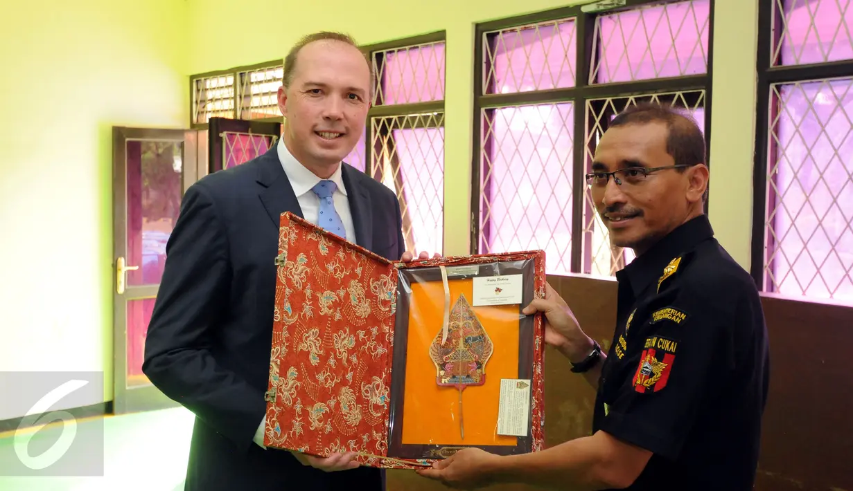 Menteri Imigrasi Australia, Peter Dutton (kiri) menerima tanda mata dari Kapus Kepatuhan Internal Dirjen Bea Cukai, Oentarto Wibowo saat berkunjung ke satuan K-9 Dirjen Bea Cukai Jakarta, Kamis (19/11/2015). (Liputan6.com/Helmi Fithriansyah)