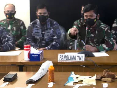 Panglima TNI Hadi Tjahjanto (tengah) menyampaikan keterangan dan menunjukkan puing-puing yang ditemukan dalam operasi pencarian kapal selam KRI Nanggala 402 di Pangkalan Udara Militer Ngurah Rai, Bali, Sabtu (24/4/2021). KRI Nanggala 402 dinyatakan tenggelam atau subsunk. (AP Photo/Firdia Lisnawati)