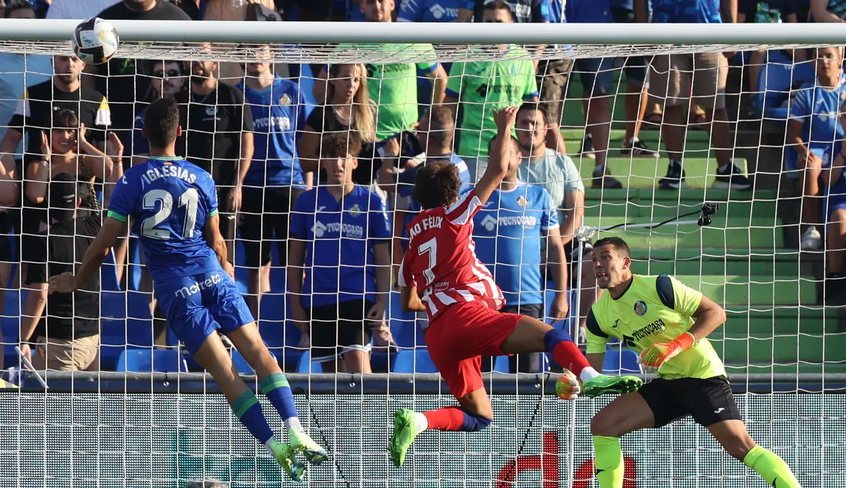 Pemain Getafe Juan Iglesias (kiri) berebut bola dengan pemain Atletico Madrid Joao Felix (tengah) di sebelah kiper Getafe David Soria pada pertandingan sepak bola Liga Spanyol di Stadion Alfonso Perez Coliseum, Getafe, Spanyol, 15 Agustus 2022. Atletico Madrid menang 3-0. (Thomas COEX/AFP)