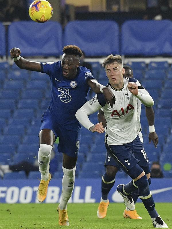 Penyerang Chelsea, Tammy Abraham berebut bola dengan bek Tottenham Hotspur, Joe Rodon pada pekan ke-10 Liga Inggris 2020/2021 di Stamford Bridge, Minggu (29/11/2020). Derby London antara Tottenham Hotspur kontra Chelsea berakhir imbang tanpa gol. (Justin Tallis/Pool via AP)