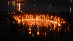 Polisi India menyalakan lilin di Sangam saat festival 'Dev Deepawali,' atau festival cahaya, di Allahabad, Rabu (25/11).  Festival ini adalah perayaan atas kemenangan kebaikan atas kejahatan. (AFP PHOTO/Sanjay Kanojia)