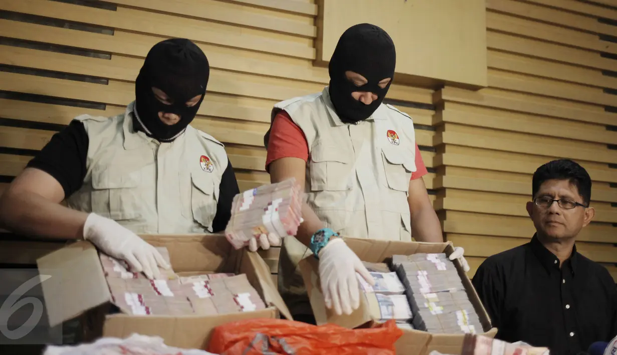 Penyidik KPK menunjukkan barang bukti uang OTT Bupati Klaten di Gedung KPK, Jakarta, Sabtu (31/12). Barang bukti uang sejumlah 2 milyar digunakan untuk suap pengaturan jabatan di lingkungan Pemerintah Kabupaten Klaten. (Liputan6.com/Helmi Afandi)