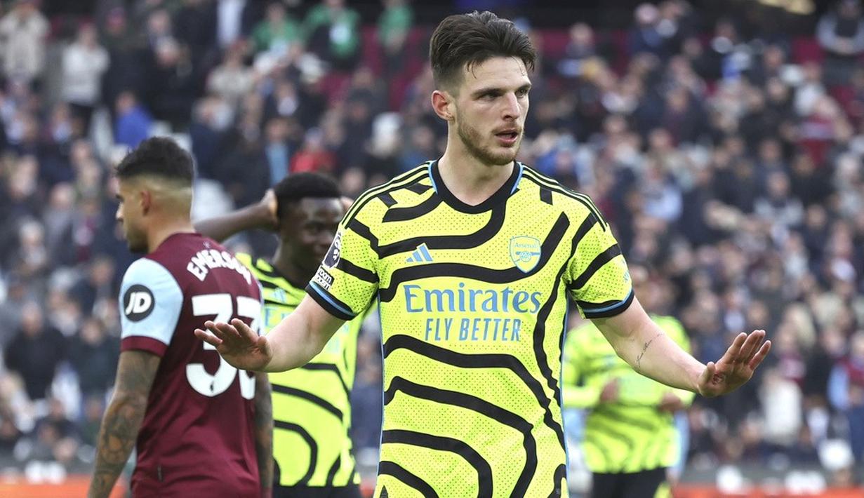 Pemain Arsenal, Declan Rice, menahan diri untuk tidak berselebrasi setelah mencetak gol ke gawang West Ham United dalam duel pekan ke-24 Premier League 2023/2024 di Stadion London, Minggu (11/2/2024). The Gunners menang setengah lusin tanpa balas atas tuan rumah. (AP Photo/Ian Walton)