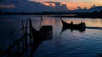 Nelayan berangkat melaut dengan perahu mereka saat fajar pada Hari Bumi di pantai Kajhu, provinsi Aceh (22/4/2021).  Kini hari bumi diperingati di lebih dari 175 negara dan dikoordinasi secara global oleh Jaringan Hari Bumi. (AFP/Chaideer Mahyuddin)