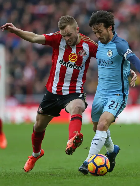 Gelandang Manchester City, David Silva berusaha mengontrol bola dari gelandang Sunderland, Sebastian Larsson pada lanjutan Liga Premier Inggris di Stadion Light, Sunderland, (5/3). City menang atas Sunderland dengan skor 2-0. (AFP Photo / Scott Heppell)