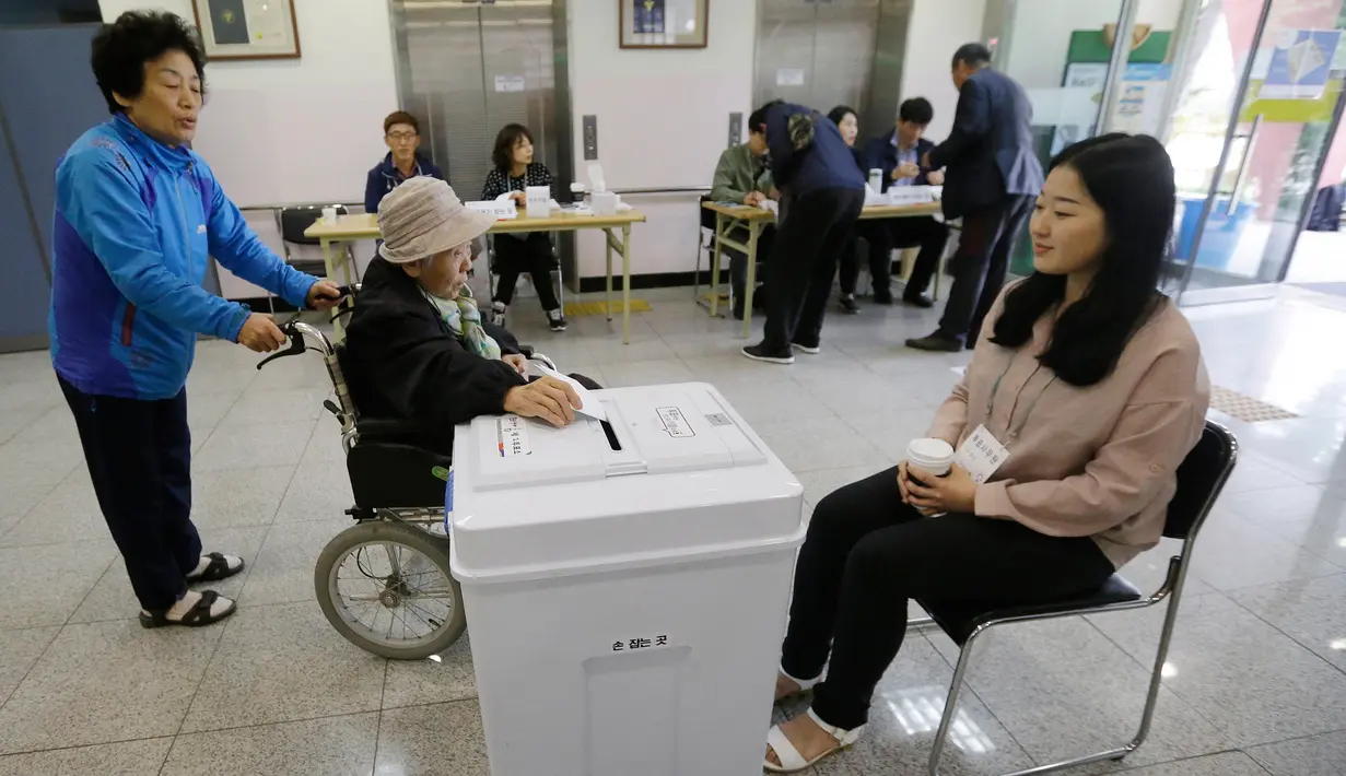 Seorang wanita memasukkan surat suara di sebuah TPS di Seoul, Korea Selatan (Korsel), Selasa (9/5). Warga Korsel menggunakan hak suaranya untuk memilih presiden baru setelah pemakzulan Park Geun-hye yang dijerat skandal korupsi. (AP Photo/Ahn Young-joon)