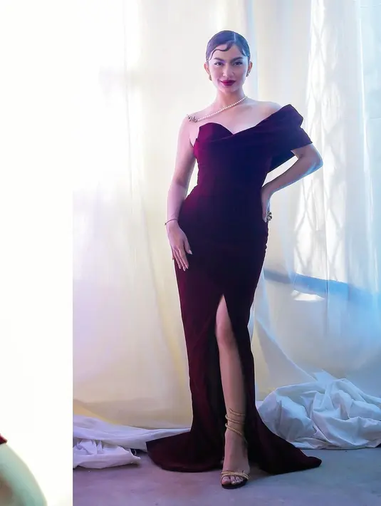 Pesona Ariel Tatum dibalut tube dress ungu. Dress ini memiliki detail lengan yang asimetris dan high slit. Ariel Tatum menyempurnakan penampilannya dengan gaya rambut yang sleek dan makeup bold, serta pulasan lipstik merah. [Foto: Instagram/arieltatum]