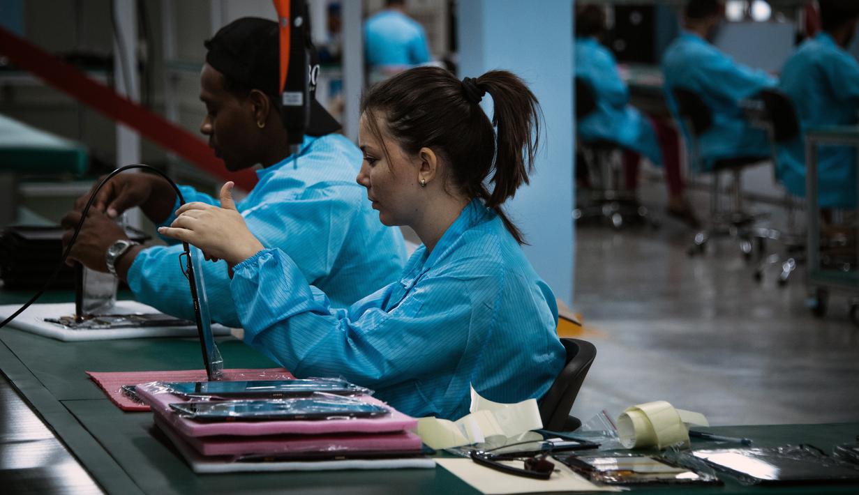 Teknisi wanita menyelesaikan proses perakitan tablet PC berteknologi Haier China di Gedeme, Havana, Kuba (15/5). Kuba-China menjalani kemitraan dalam bidang industri elektronik komputer. (AFP Photo/Adalberto Roque)