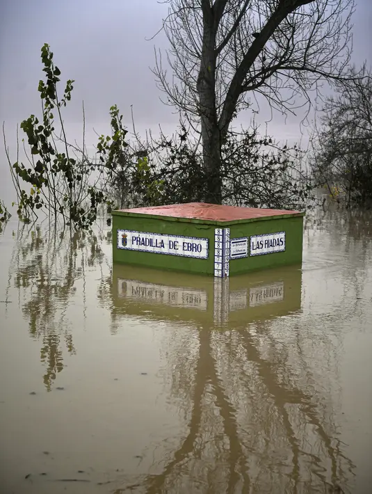 Sebuah tanda menunjukkan ketinggian permukaan air, tujuh meter (22 kaki), di daerah banjir dekat Sungai Ebro di desa kecil Pradilla de Ebro, provinsi Aragon, Spanyol utara (13/12/2021). Hujan deras menyebabkan banjir di Spanyol utara. (AP Photo/Alvaro Barrientos)
