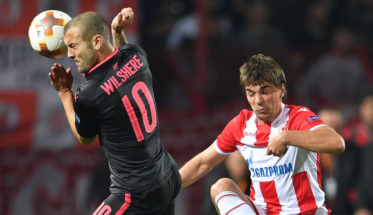 Aksi pemain Arsenal, Jack Wilshere (kiri) berebut bola dengan pemain Belgrade Crvena Zvezda, Filip Stojkovic pada laga grup H Liga europa di Stadion Rajko Mitic, (19/10/2017). Arsenal menang 1-0. (AFP/Andrej Isakovic)