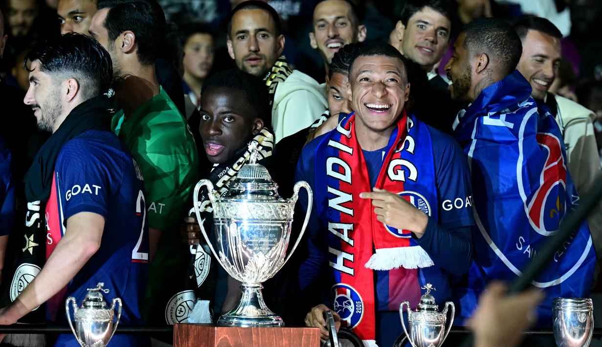 Penyerang Paris Saint-Germain, Kylian Mbappe (kedua kanan) merayakan dengan trofi juara Ligue 1 Prancis di stadion Parc des Princes, Paris pada 12 Mei 2024. (MIGUEL MEDINA/AFP)