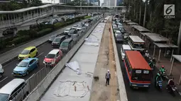 Sejumlah kendaraan terjebak macet di samping penataan jalan dan trotoar di Jalan Sudirman, Jakarta, Selasa (17/4). Trotoar tersebut akan dilebarkan menjadi 9 hingga 12 meter. (Liputan6.com/Arya Manggala)
