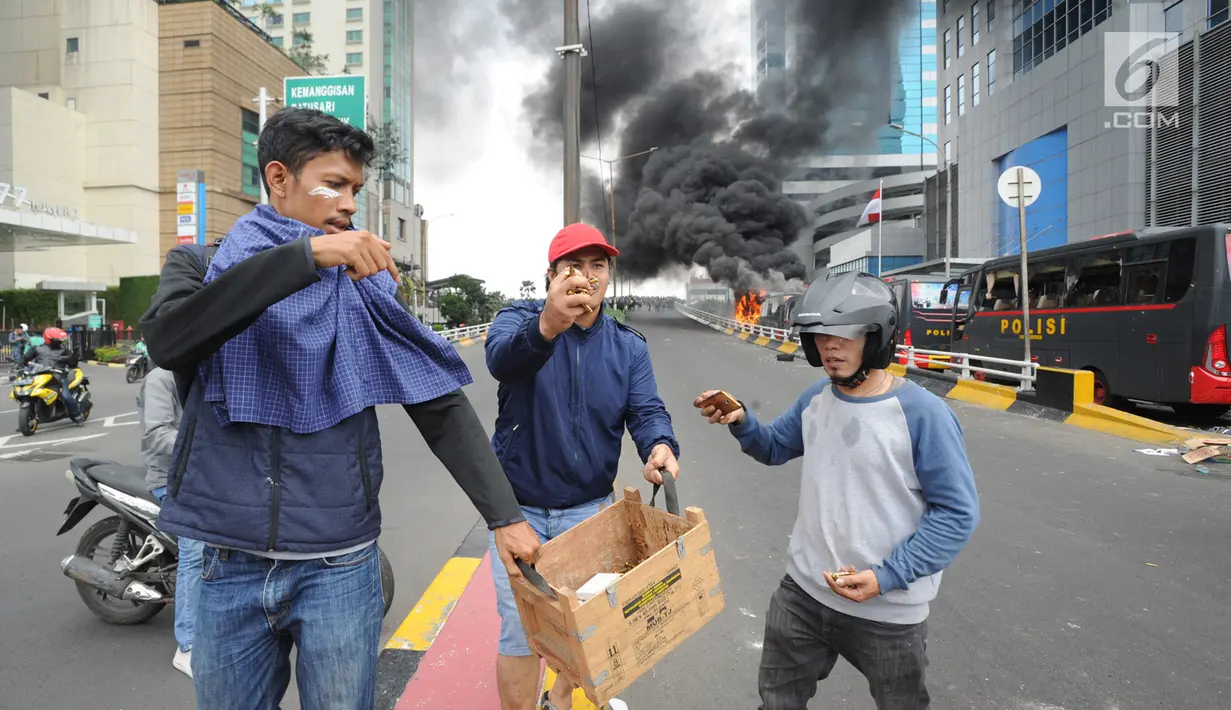 Warga menunjukkan peluru dari kendaraan Polisi yang terbakar di Jalan Brigjen Katamso, Slipi, Jakarta, Rabu (22/5/2019). Belum diketahui penyebab terbakarnya dua bus yang terparkir bersama bus polisi lainnya dilokasi tersebut. (merdeka.com/Arie Basuki)