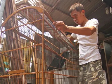 Perajin membuat sangkar burung di YR Sangkar, Cimanggis, Depok, Jawa Barat, Rabu (17/3/2021). Perajin mengkatakan produksi sangkar burung yang dijual Rp 150 ribu hingga Rp 500 ribu per sangkar alami peningkatan penjualan 50 persen selama pandemi COVID-19. (Liputan6.com/Herman Zakharia)
