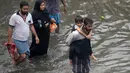 Orang-orang mengarungi jalan yang banjir setelah hujan lebat di Chennai, India (8/11/2021). Chennai dilanda Curah Hujan Terberat Sejak 2015,  Pihak berwenang Keluarkan Peringatan Banjir. (AFP/Arun Sankar)