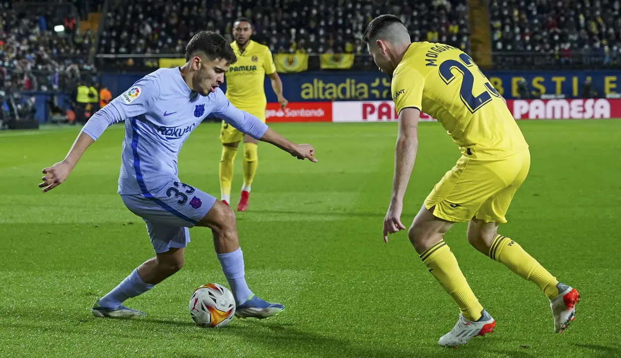 Penyerang Barcelona Abde Ezzalzouli berebut bola dengan gelandang Villarreal Moi Gomez pada lanjutan La Liga di Estadio de la Ceramica, Minggu (28/11/2021) dini hari WIB. Barcelona menang dengan menghajar tuan rumah Villlarreal 3-1. (AP Photo/Alberto Saiz)