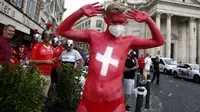 Suporter Swiss yang tubuhnya dicat dengan warna bendera Swiss berjalan di pusat kota Roma menjelang laga Grup A Euro 2020 antara Italia dan Swiss, Rabu (16/6/2021). Dalam laga tersebut, Timnas Italia menghajar Swiss dengan skor 3-0. (Cecilia Fabiano/LaPresse via AP)