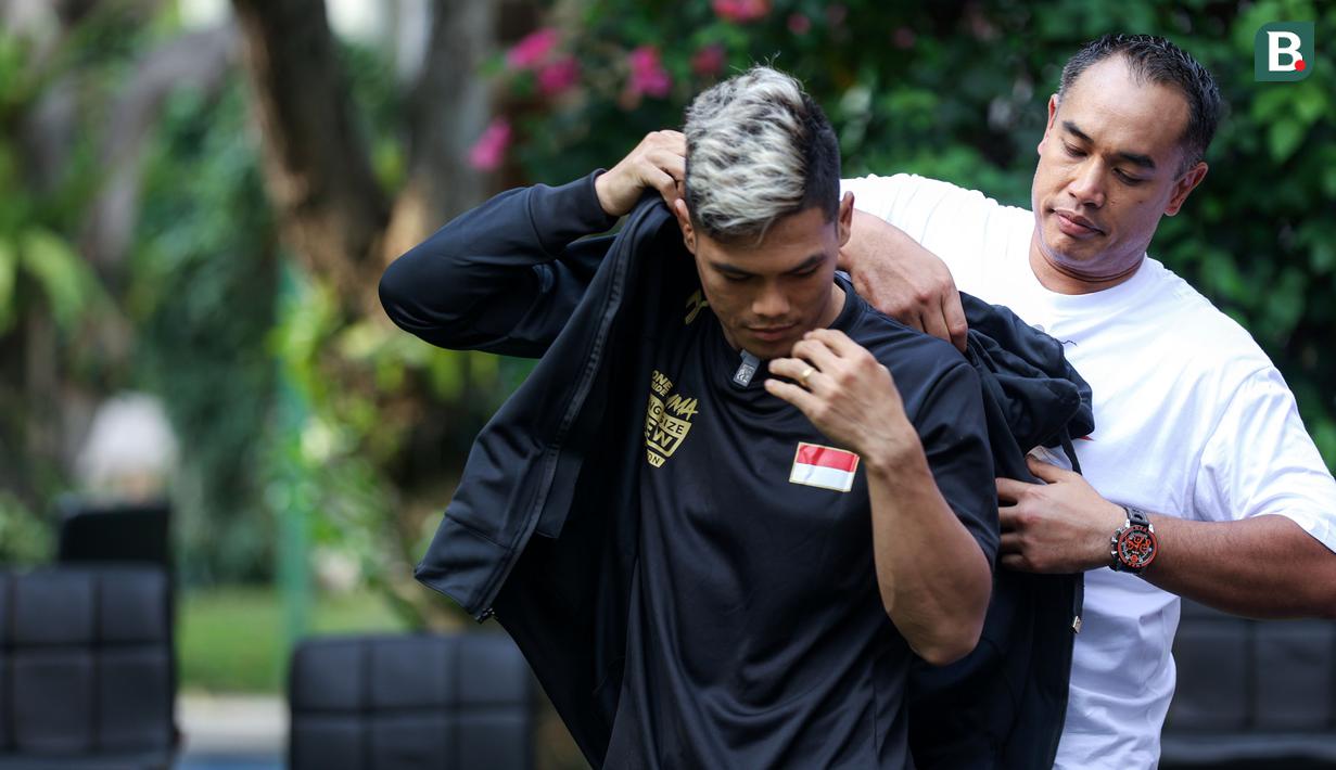 Ketua Umum Komite Olahraga Beladiri Indonesia (KOBI), Ardi Bakrie memasangkan jaket kepada perwakilan fighter saat konferensi pers mengenai pemberangkatan atlet MMA ke China yang berlangsung di Menteng, Jakarta Pusat, Senin (21/10/2024). (Bola.com/Bagaskara Lazuardi)