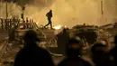 <p>Seorang demonstran berlarian pada malam ketiga protes yang dipicu oleh penembakan fatal polisi terhadap seorang pengemudi berusia 17 tahun di Nanterre, Prancis, Jumat (30/6/2023). (AP Photo/Aurelien Morissard)</p>