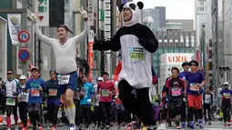 Peserta berkostum panda melintas di distrik perbelanjaan Ginza saat ambil bagian dalam Tokyo Marathon 2018 , Minggu (25/2). Tokyo Marathon merupakan ajang bergengsi lari kelas dunia yang diikuti pelari dari berbagai belahan negara. (AP/Shizuo Kambayashi)