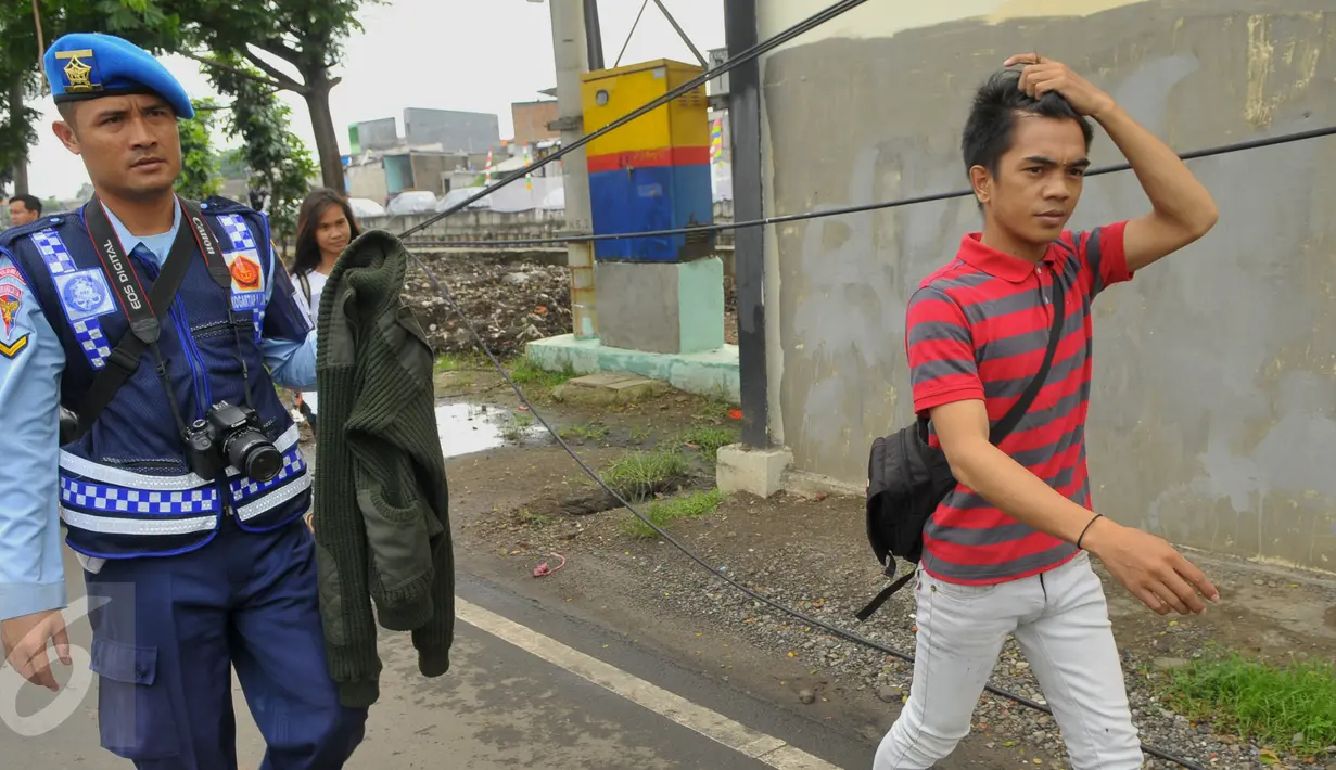 Petugas membawa jaket bermotif militer milik seorang pemotor saat Operasi Gaktib Garnisun Tetap 1 di kawasan Pesing, Jakarta,  Kamis, (11/2/2016). Razia dilakukan untuk menertibkan aksesoris berlambangkan TNI dan Polri. (Liputan6.com/Faisal R Syam)