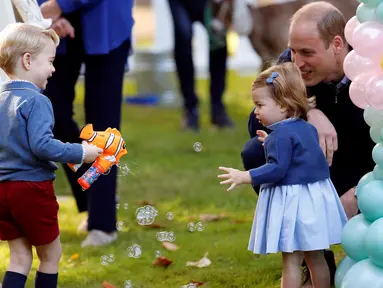 Pangeran George dan Putri Charlotte terlihat bergembira saat bermain pistol gelembung sabun dalam sebuah pesta untuk anak-anak di Government House di Victoria, British Columbia, Kanada, (29/9). (REUTERS/Chris Wattie)