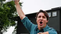 Perdana Menteri Kanada Justin Trudeau mengangkat topi koboinya saat menyapa warga saat acara Calgary Stampede di Calgary, Alberta, Kanada (15/7). (Jeff McIntosh / The Canadian Press via AP)