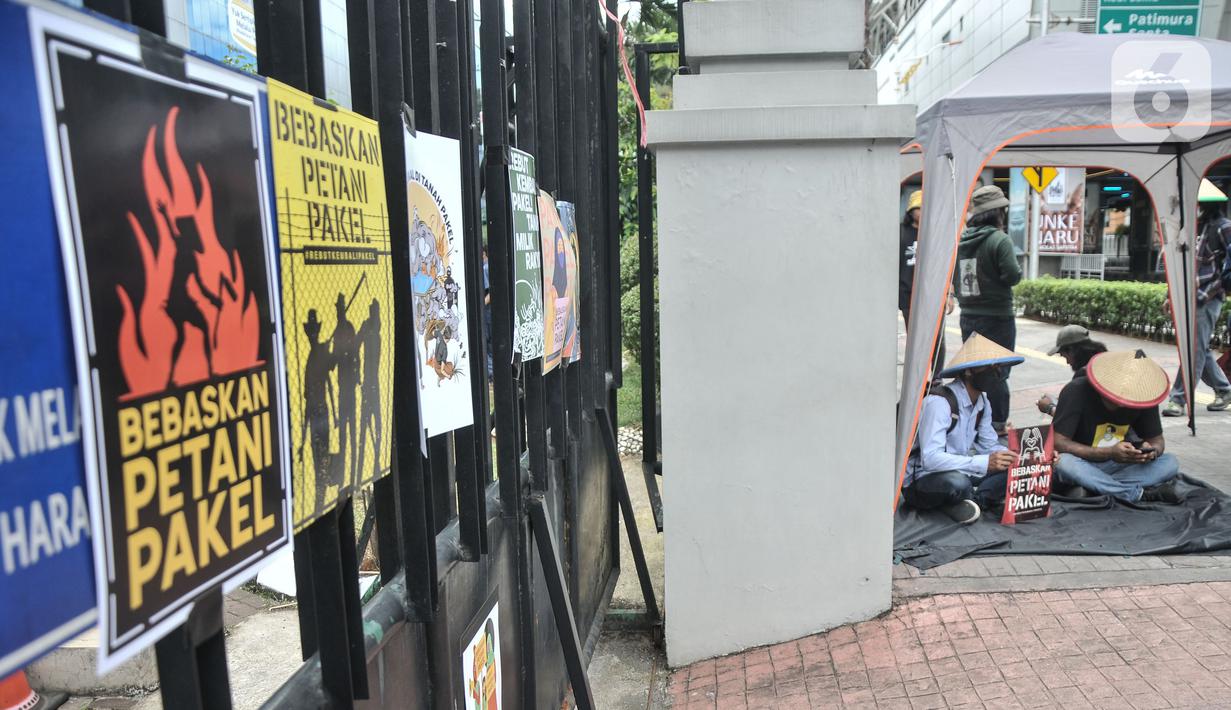Aktivis Gerakan Rakyat untuk Kedaulatan Agraria memasang poster saat aksi mogok makan di depan Kantor Kementerian ATR/BPN, Jakarta, Senin (20/2/2023). Dalam aksinya mereka mendesak Kapolri untuk membebaskan tiga petani yang ditangkap oleh pihak Kapolda Jatim. (merdeka.com/Iqbal S Nugroho)